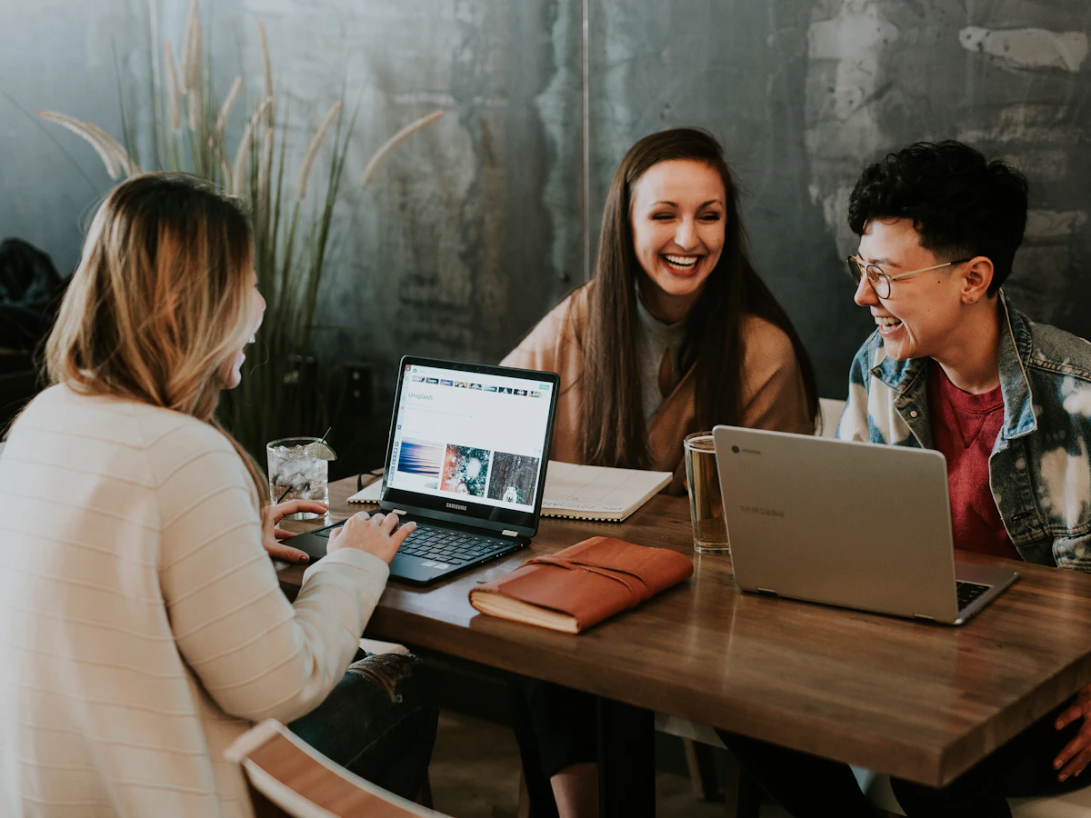A diverse team working together around a laptop